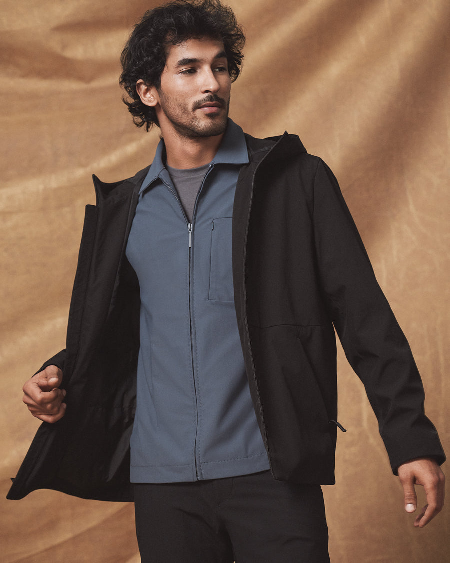 Man wearing a black Dockers® go jacket over a blue shirt against a brown background