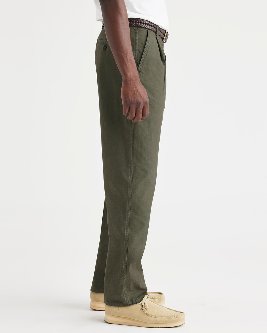 Side view of model wearing Army Green Men's Relaxed Taper Fit Original Pleated Chino Pants.