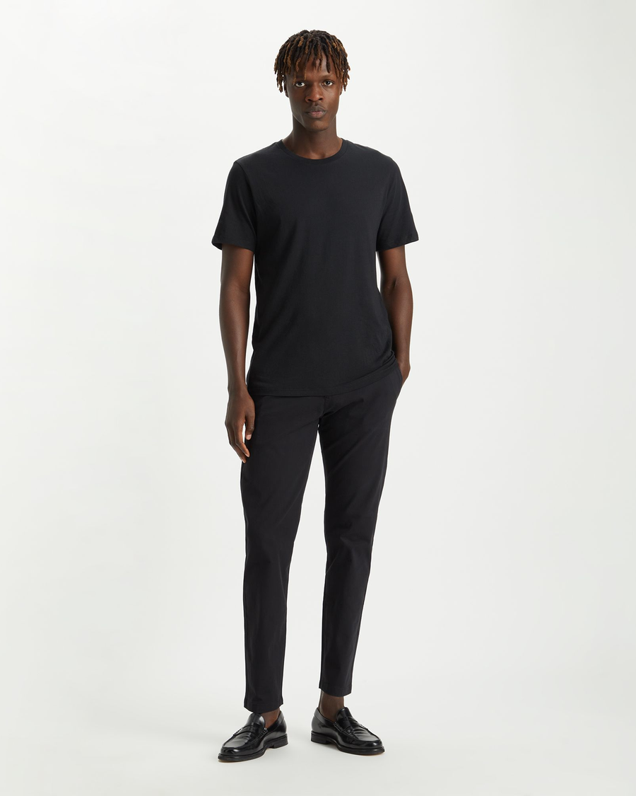 Front view of model wearing Black Men's Slim Tapered Fit Smart 360 Flex Alpha Chino Pants.