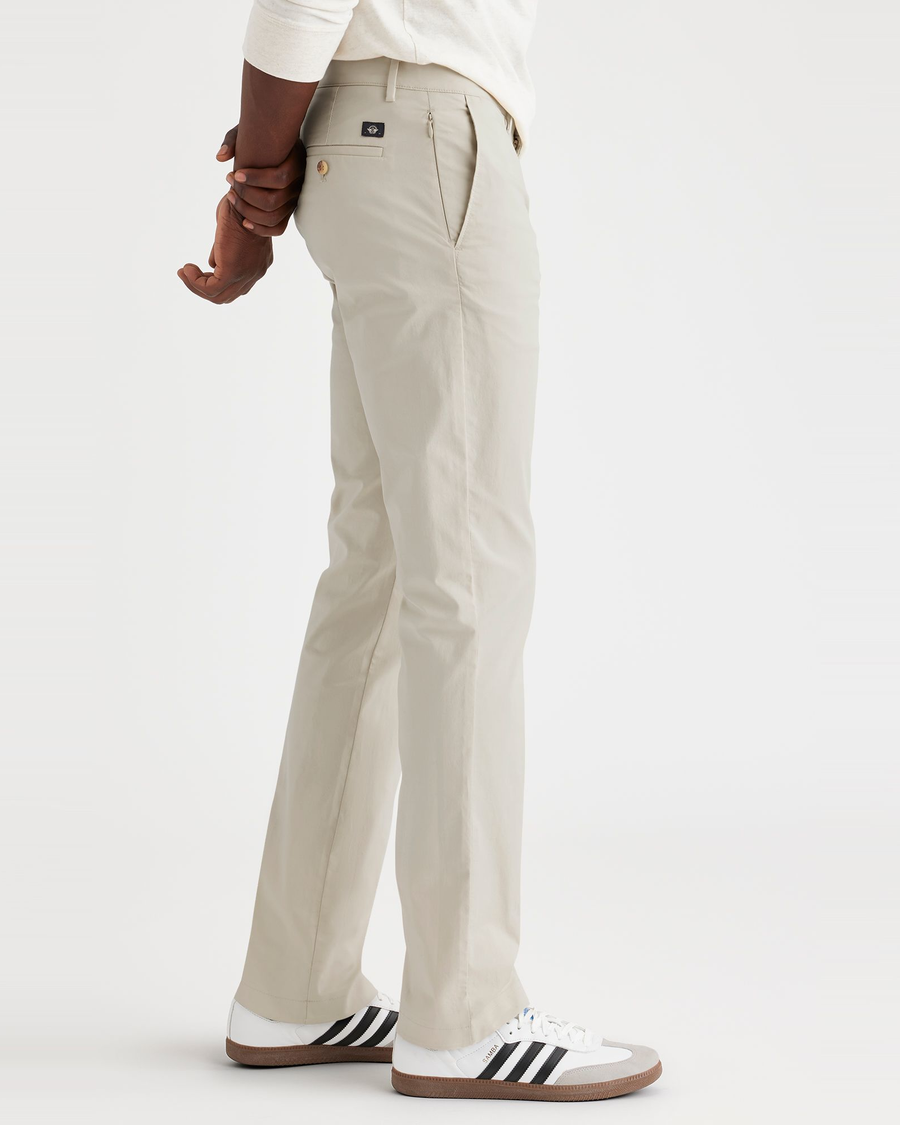 Side view of model wearing Grit Men's Slim Fit Smart 360 Flex Alpha Chino Pants.