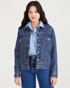 Front view of model wearing Medium Indigo Stonewash Women's Regular Fit Original Trucker Jacket.