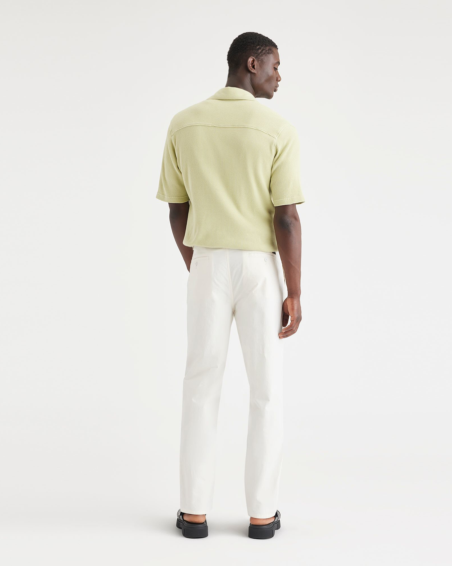 Back view of model wearing Natural Men's Relaxed Taper Fit Original Pleated Chino Pants.