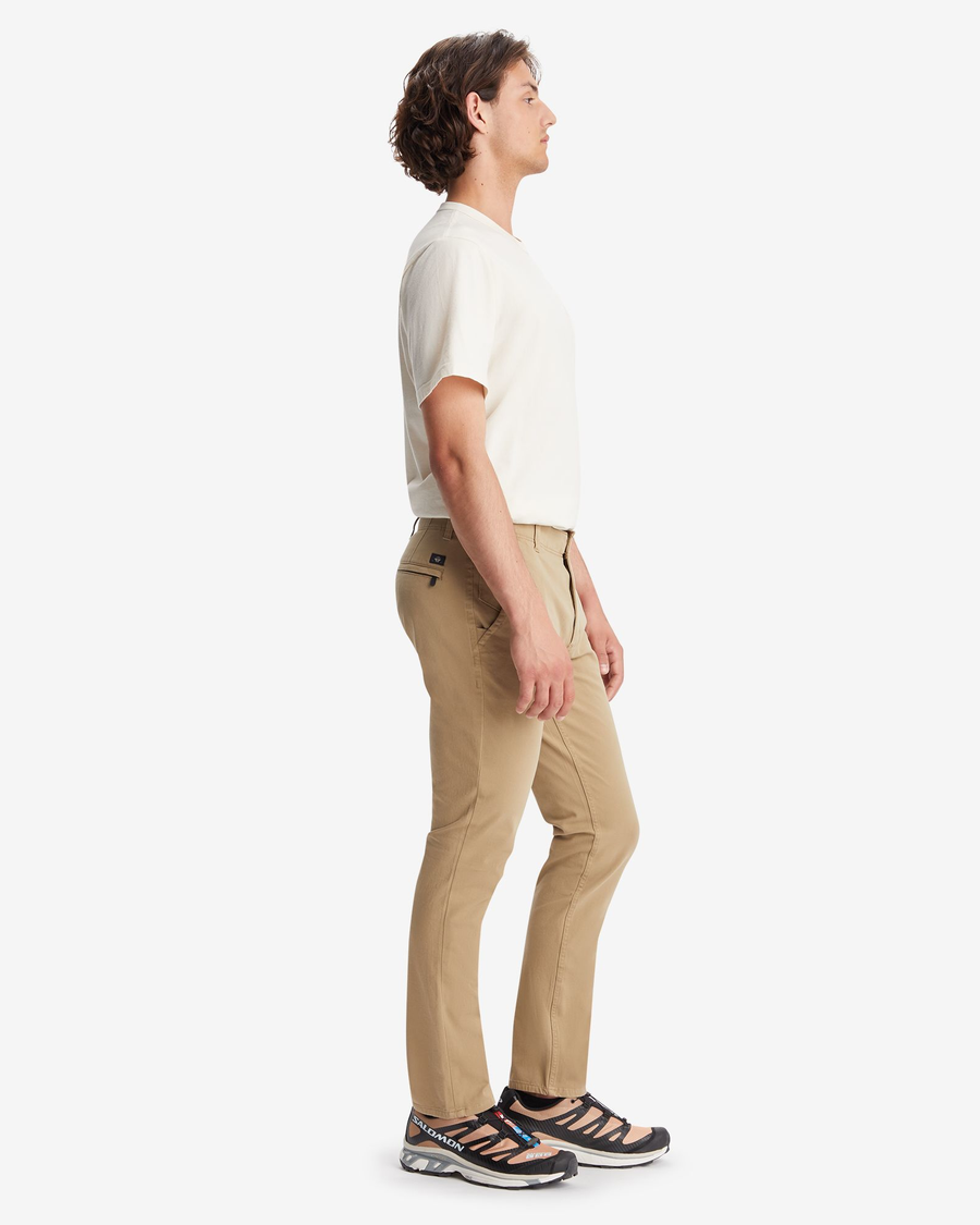 Side view of model wearing New British Khaki Men's Skinny Fit Smart 360 Flex Alpha Khaki Pants.