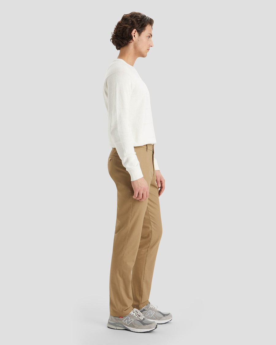 Side view of model wearing New British Khaki Signature Iron Free Khakis, Slim Fit with Stain Defender®.