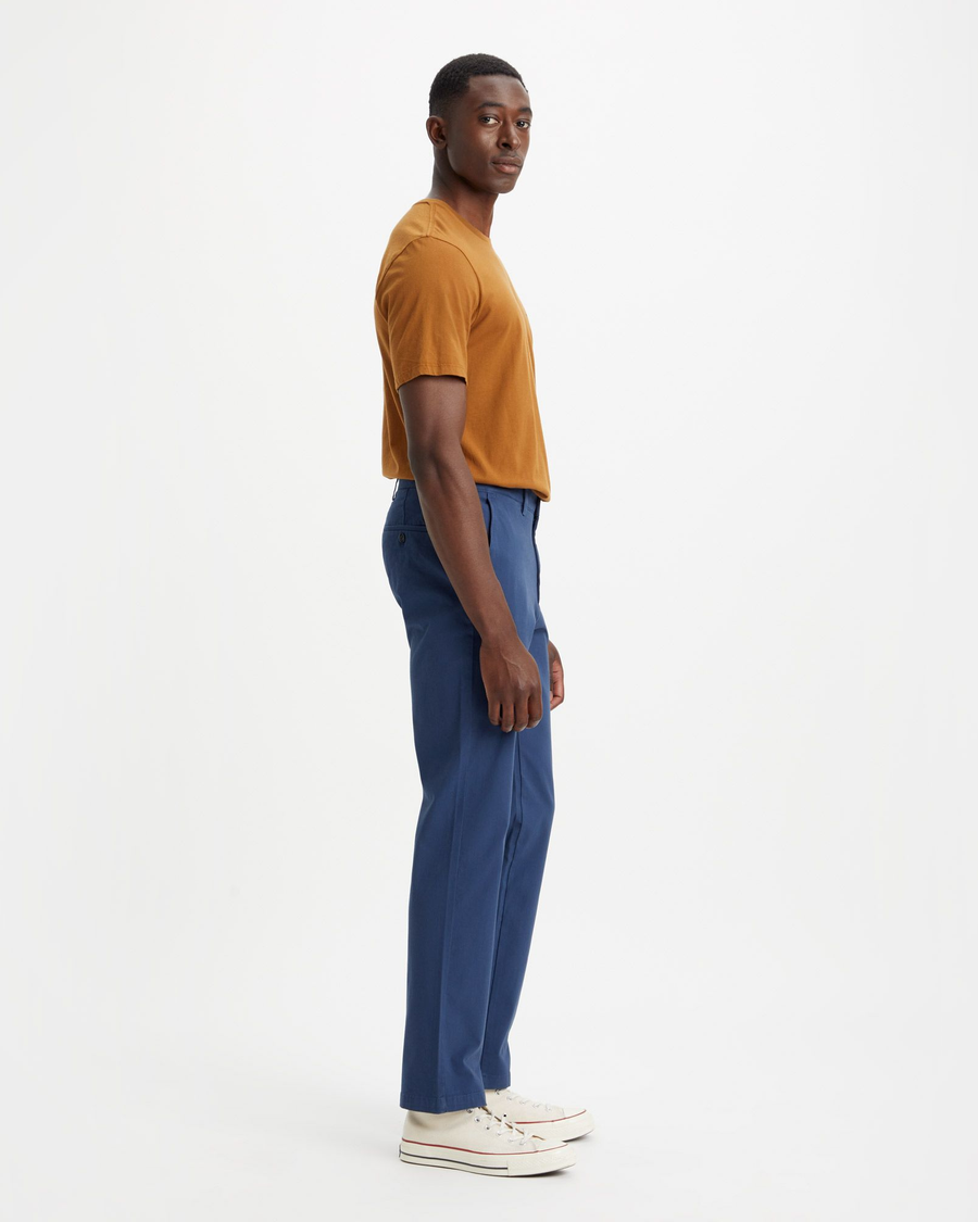 Side view of model wearing Ocean Blue Men's Slim Fit Smart 360 Flex Alpha Chino Pants.